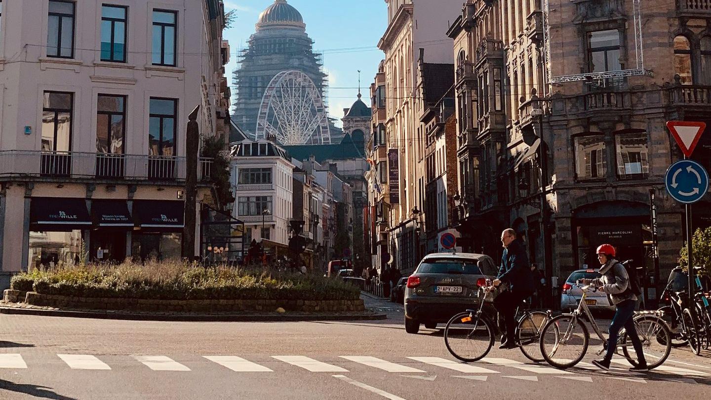 a group of people riding bikes down a street next to tall buildings